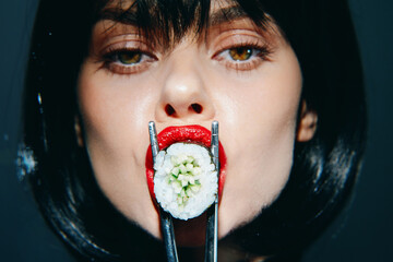 Woman with sushi mouth, bold red lips, and fresh sushi on chopsticks, showcasing a unique blend of fashion and culinary art with an expressive look.
