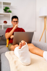 Man working with laptop recovering from fractured foot