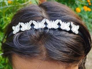 Dark Hair Adorned with a Sparkling Silver Butterfly Headband Accessory