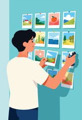 Person pinning colorful landscape photos onto a wall
