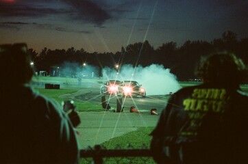 Nighttime Drift Cars Creating Smoke on Track with Spectators Watching © Alex
