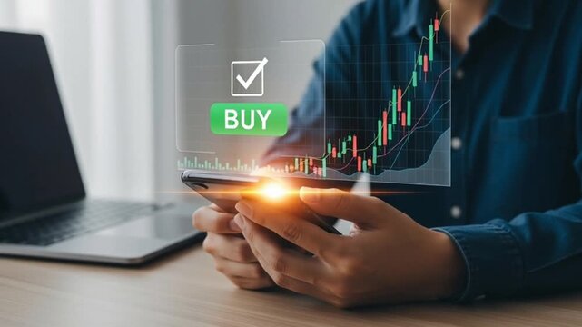 Person holding mobile device with financial graph and buy option displayed