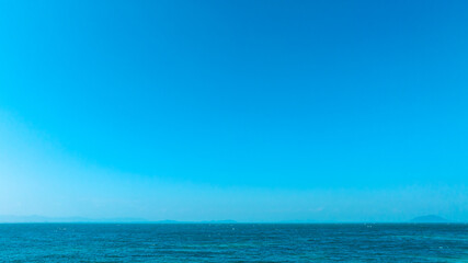 Obraz premium Nature of the ocean and blue sky Summer with sunshine, sandy beaches, clear blue waters sparkling against the blue sky. on an island with good ecology and environment Background for summer vacation