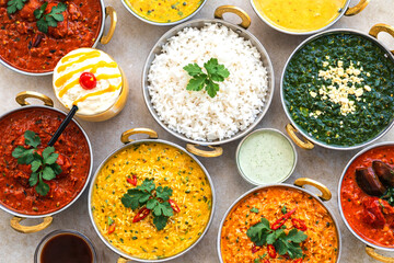 Culinary mosaic: An assortment of diverse, delicious Indian dishes presented in elegant serving bowls, tempting the taste buds with their vibrant colors and enticing textures.