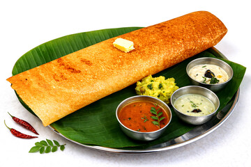 Golden Dosa Delight: A golden-brown dosa, a South Indian culinary masterpiece, is served alongside a medley of flavorful accompaniments on a banana leaf, offering a tantalizing feast for the senses.