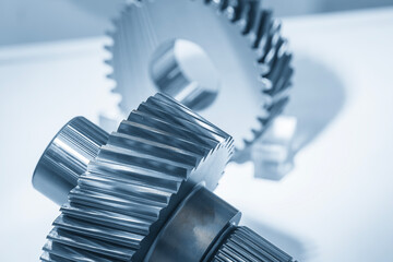 Close up the transmission bevel gear spare parts in the light blue scene. The abstract scene of gear part of automotive transmission system.