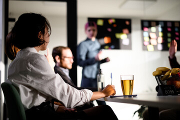 Business meeting in modern office with diverse team discussing strategy and ideas, highlighting collaboration and engagement in a creative workspace setting