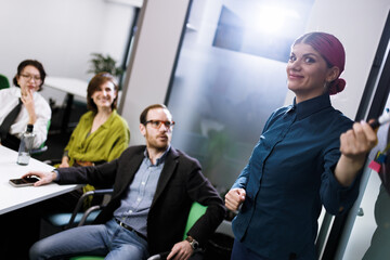 Businesspeople engaging in a productive meeting while a presenter explains ideas to a captivated audience in a modern office setting