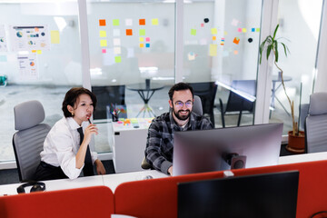 Business professionals collaborate in a modern office setting while discussing ideas and reviewing projects at their workspace in the afternoon