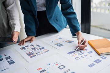 Developer team brainstorming user interface and experience designs for mobile application ux ui graphic prototype.