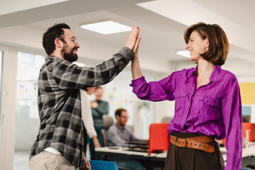 Businesspeople celebrating a successful collaboration in a modern office during afternoon meetings