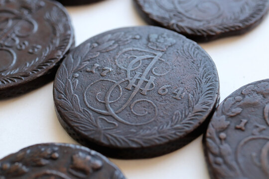 A collection of vintage 5 kopecks of Catherine II coins with intricate designs and inscriptions, showcasing historical elements and craftsmanship
