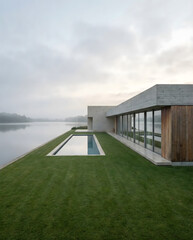 Fototapeta premium Modern minimalist house with swimming pool and lake view at dusk