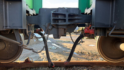 Close-up view of train couplings and wheels, showcasing mechanical components and connections between train cars