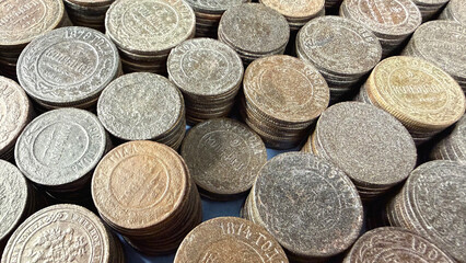 Stacks of vintage Russian Empire coins with intricate designs and varying patinas.