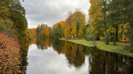 Serene autumn landscape with colorful trees reflecting in a calm river.