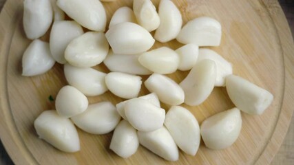 Chopping garlic for cooking in a kitchen setting