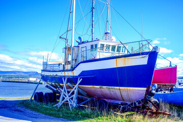 Commercial fishing boats hauled onto shore for the off season in Gros Morne National Park, Newfoundland. Vessels resting on supports near the coast during fall.
