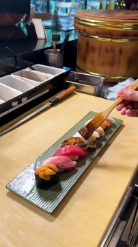 Chef Brushing Sauce on Assorted Nigiri Sushi Platter