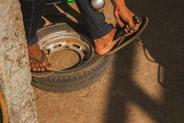 "Mangalore, Karnataka,India - april 2nd 2021:Worker removing the tube from the tire with the tools after it gets punctured"