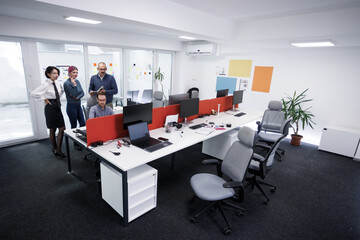 Business meeting among colleagues in a modern open office space with collaborative workstations and a casual atmosphere during daytime
