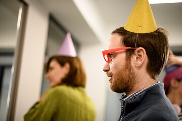 Business celebration with party hats at an office gathering in a modern workspace during the afternoon