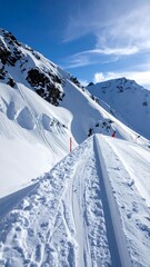 Stunning vista of snowy mountains under a bright blue sky. A pathway, covered in fresh snow, leads towards the peak