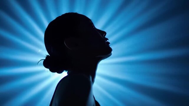 A woman's profile silhouette against a vibrant blue background with radiant beams of light emanating from behind her head