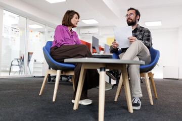 Business meeting between two professionals discussing project details in a modern office setting
