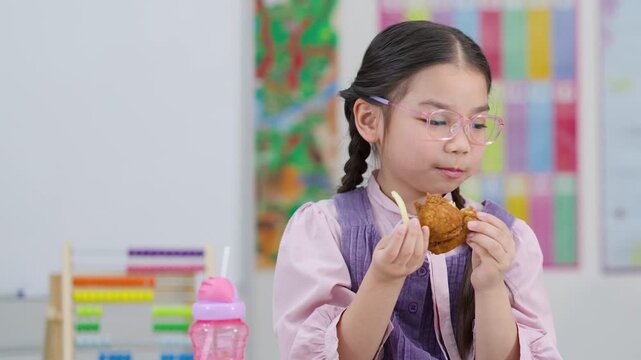 Schoolgirl Eating Fried Chicken During Classroom Lunchtime Break
