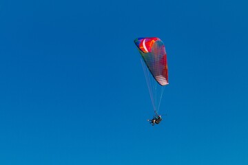 Paraglider flying in the blue sky