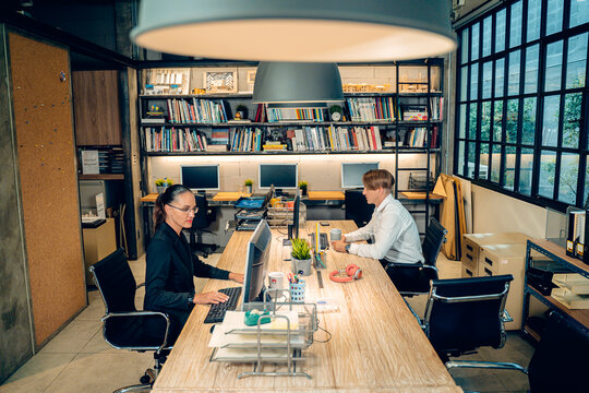 Caucasian business team man woman working at desk in modern creative office. Professional corporate partners use computer planning digital strategy. Industrial loft startup agency workspace background - Powered by Adobe