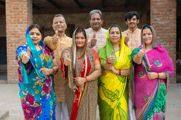 Group of rural indian men and women do thumbs up at camera. People of india. Village life.