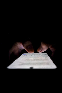 Night, cybersecurity and hands typing with phone for texting, internet troll or person cyberbullying. Dark comment, social media netizen or keyboard warrior, online bullying or hacking. vertical.
