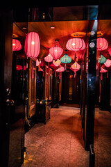 A hallway decorated with multiple red and turquoise lanterns creating a warm and stylish ambiance.