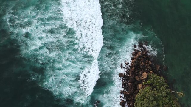 Bird's-eye view of sea waves hitting rocks in Sri Lanka Laccadive Sea