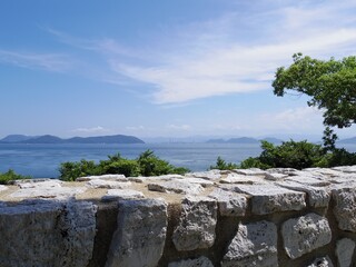 海岸の石垣越しに見る青い海と空