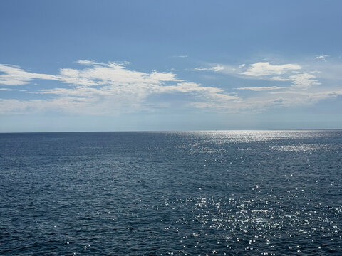 Calm sea blue glistening water and sunny sky.
