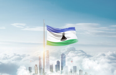 Lesotho national flag waving in sky with modern building skyline. Lesotho national flag for independence day.
