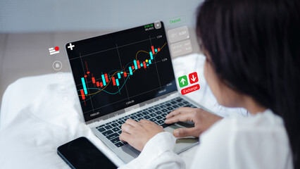 Investor Using Smartphone App and Laptop for Stock Market Trading and Data Analysis
