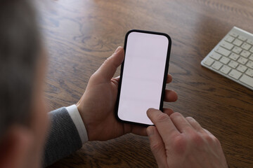 hands holding smartphone with empty blank white screen, closeup, man using mobile phone	close up