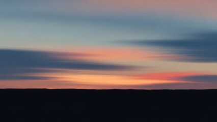 Obraz premium Serene blurred pastel sky above a dark horizon at twilight offering calm and peaceful views