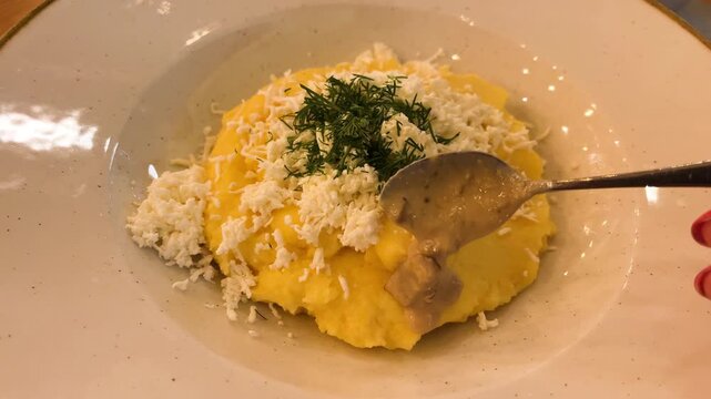 Banush corn porridge with feta cheese, cracklings, fried mushrooms and onions. Traditional Ukrainian dish of the Hutsul Carpathians.