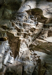 Elegance of The intricate natural light and shadow on surface of stone wall. Pattern of granite on the mountains that erode naturally, The sunlight shining through down to Limestone walls.