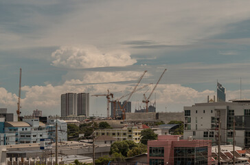 View of Construction of tall buildings with a crane and background of Dramatic sky in the city of Bangkok. Tower crane, Construction cranes, Construction and urban development concepts, Copy space.