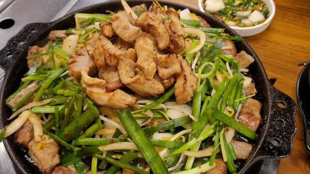 신선한 부추와 양파를 곁들여 불판 위에서 고소하게 구워지는 한국식 소곱창과 막창 구이