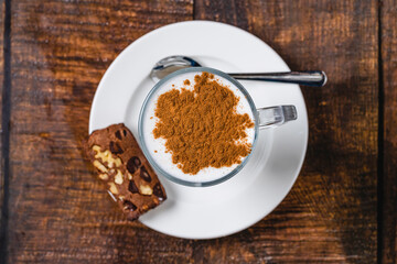 Caffe latte served with cinnamon topping on rustic wooden table