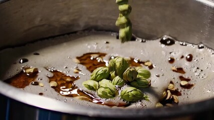 In this captivating video, the chef expertly adds fresh green cardamom pods into bubbling syrup, creating a rich aroma and flavor. The step-by-step process highlights the art of cooking with spices fo