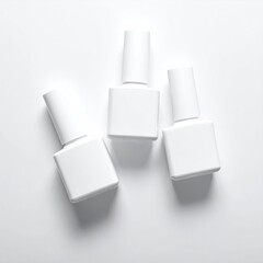 Three white nail polish bottles on a plain white background, top view