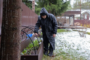 Elderly man gardening in winter backyard